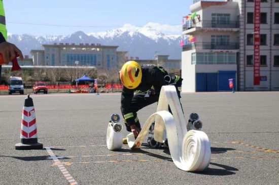 參賽人員正在進行一人三盤水帶連接操。周星攝