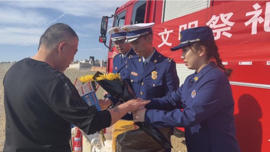 圖為克拉瑪依市消防救援支隊消防監督人員以花換紙倡導市民文明祭祀。王穎楠攝